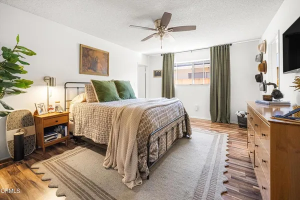 a bedroom with a bed a flat screen tv and a couch