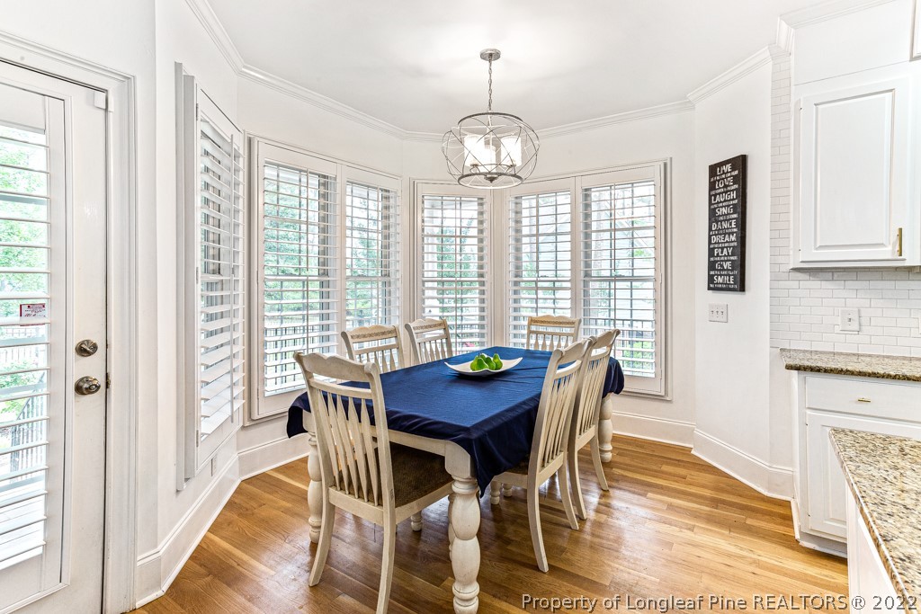 126 Falling Water Road Spring Lake, NC 28390 - Photo 25 of 47 a view of a dining room with furniture a chandelier and wooden floor