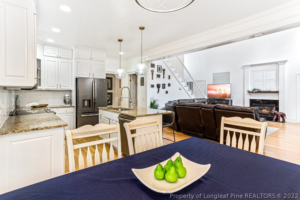 126 Falling Water Road Spring Lake, NC 28390 - Photo 26 of 47 a kitchen with stainless steel appliances granite countertop a sink dishwasher a refrigerator a stove and white cabinets with wooden floor