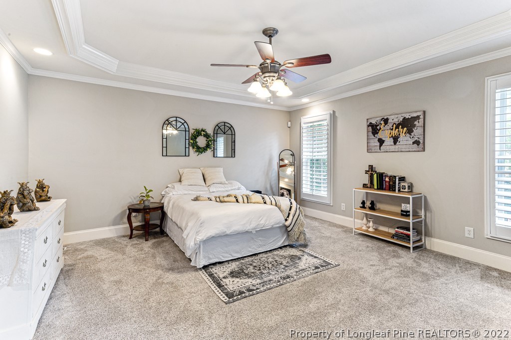 126 Falling Water Road Spring Lake, NC 28390 - Photo 32 of 47 a spacious bedroom with a bed and a chandelier