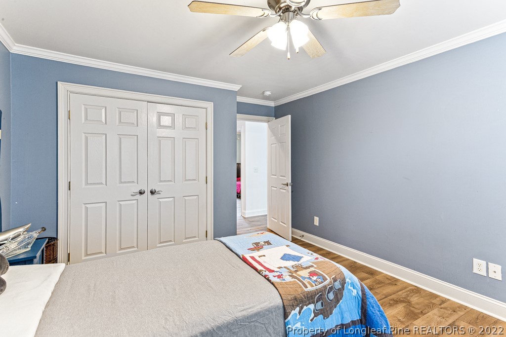 126 Falling Water Road Spring Lake, NC 28390 - Photo 41 of 47 a bedroom with a large bed and a chandelier