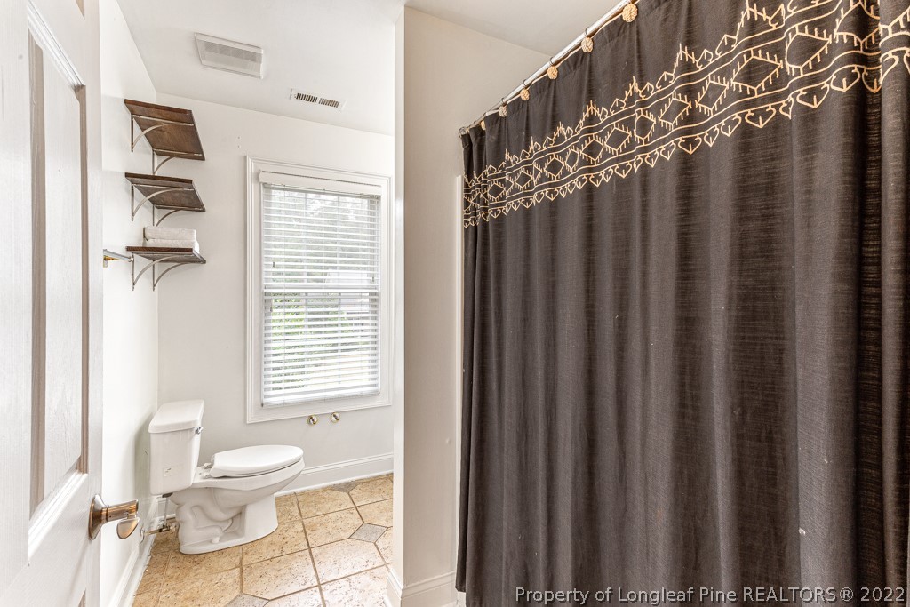 126 Falling Water Road Spring Lake, NC 28390 - Photo 44 of 47 a bathroom with a toilet a sink and a window