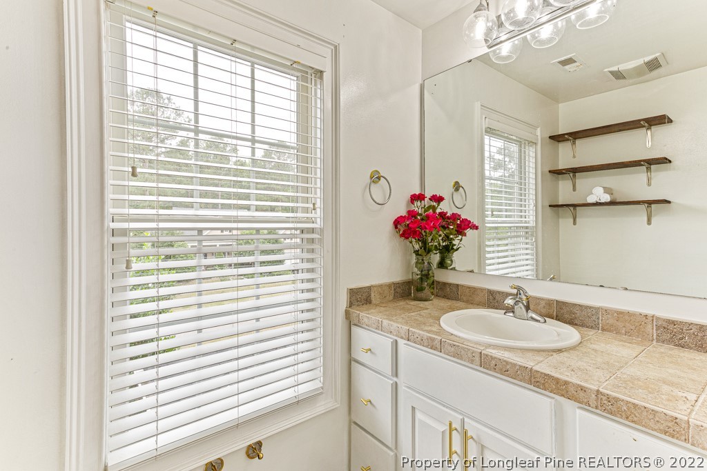 126 Falling Water Road Spring Lake, NC 28390 - Photo 45 of 47 a bathroom with a granite countertop sink and a mirror