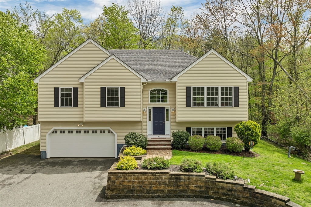 a view of a white house with large windows and a small yard