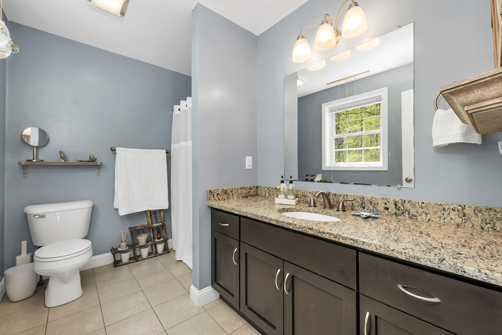 31 Danville Road Hampstead, NH 03826 - Photo 24 of 42 a bathroom with a granite countertop sink a toilet and a mirror