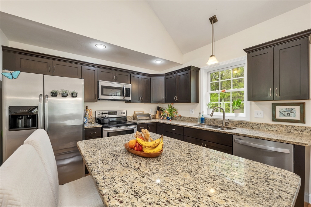 31 Danville Road Hampstead, NH 03826 - Photo 3 of 42 a kitchen with stainless steel appliances granite countertop a stove top oven a sink dishwasher a dining table and chairs with wooden floor