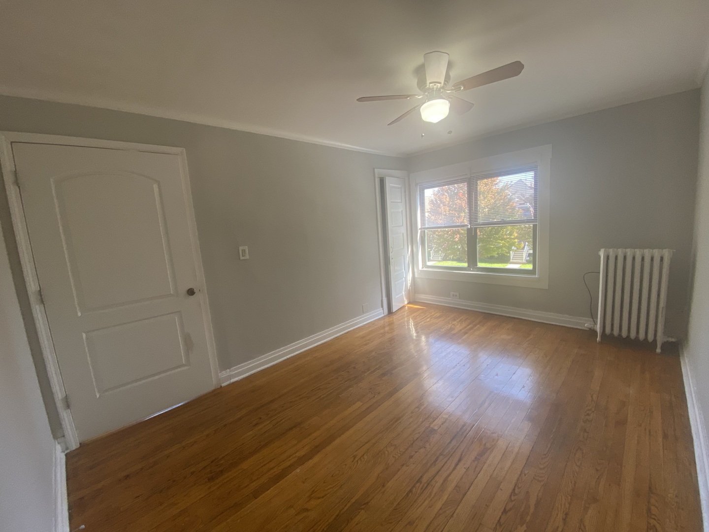4210 North Kilpatrick Avenue, Unit 2F Chicago, IL 60641 - Photo 4 of 15 an empty room with wooden floor and windows