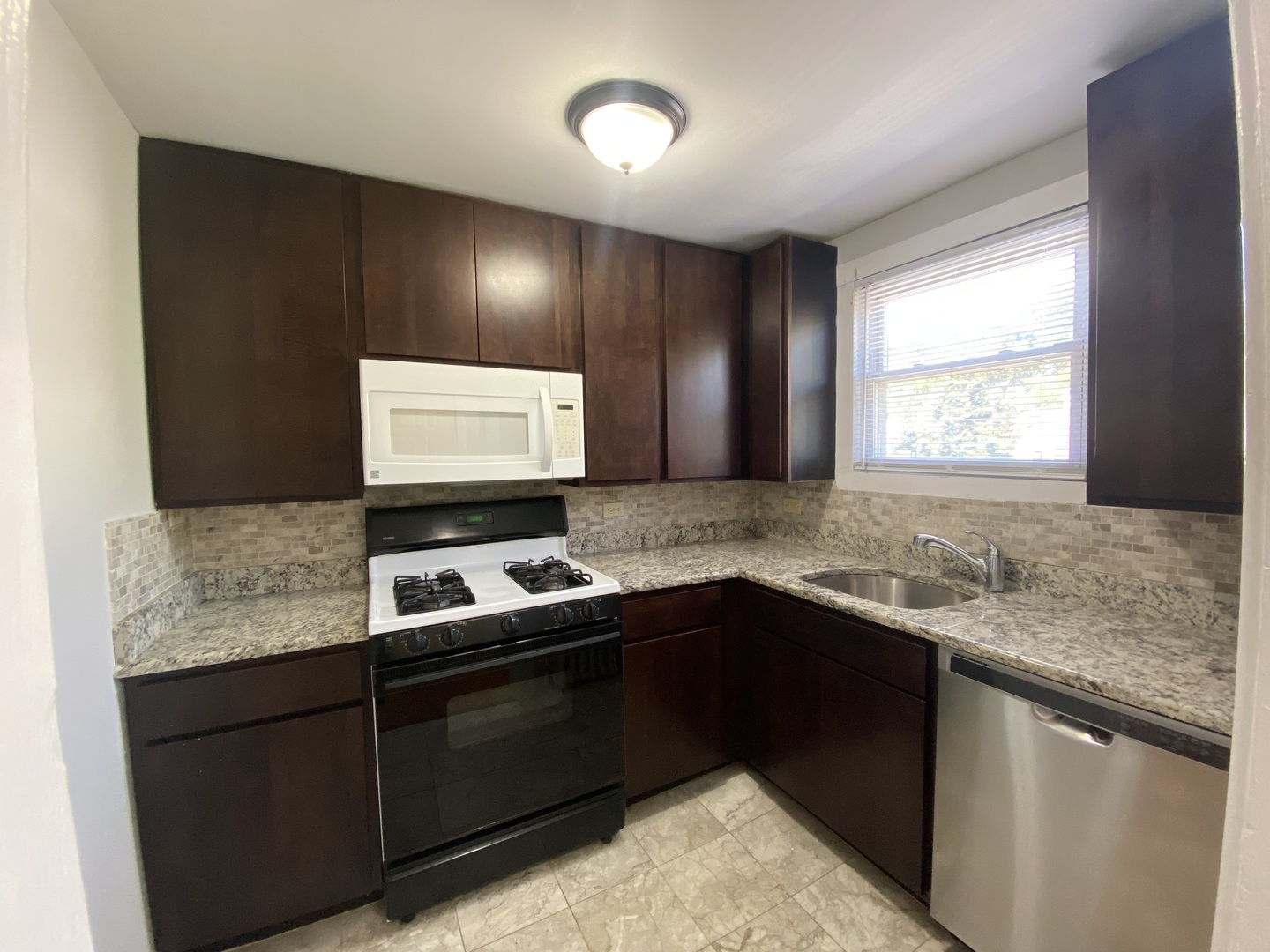 4210 North Kilpatrick Avenue, Unit 2F Chicago, IL 60641 - Photo 6 of 15 a kitchen with a sink and a window