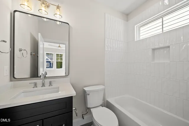 a bathroom with a sink a toilet a mirror and shower