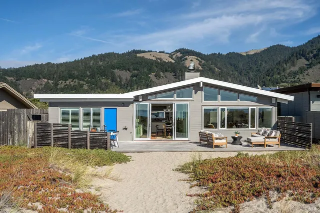 a front view of a house with a yard in the background