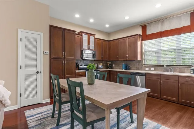 a kitchen with kitchen island granite countertop wooden floors appliances and furniture