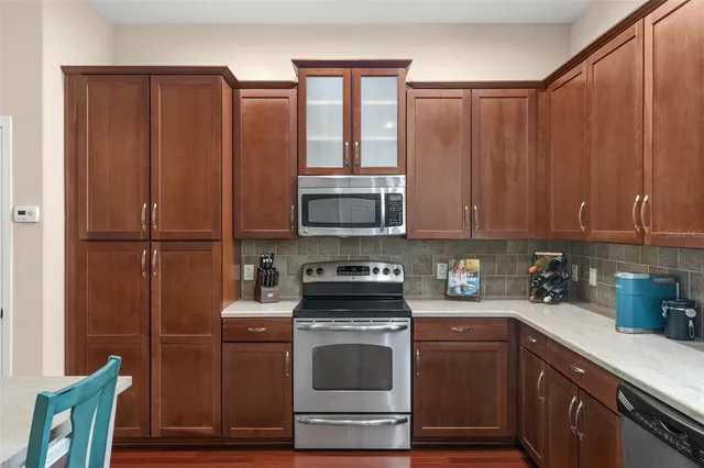 a kitchen with stainless steel appliances wooden cabinets and a stove top oven