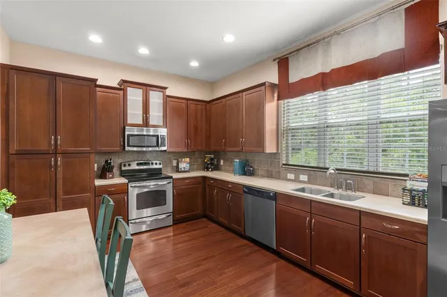 a kitchen with stainless steel appliances granite countertop sink stove top oven and cabinets