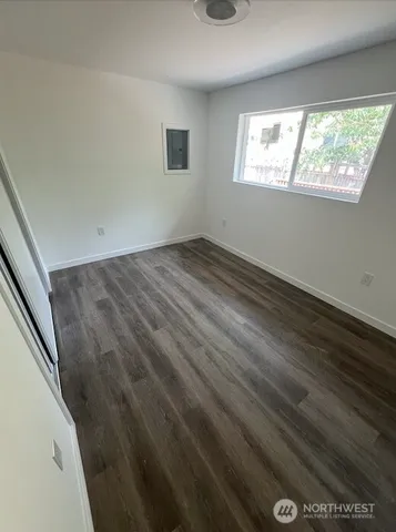 a view of empty room with wooden floor