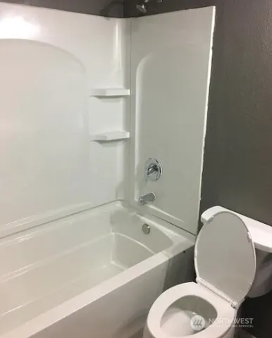 a white bath tub sitting next to a white toilet