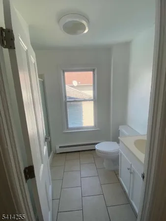 a bathroom with a toilet a sink a window and tub