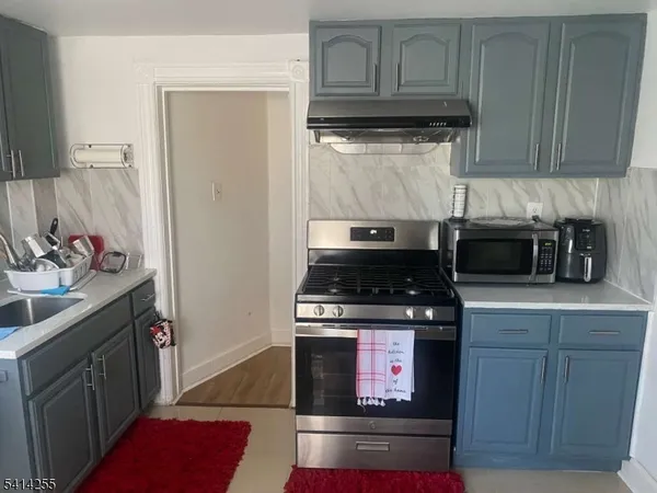 a kitchen with stainless steel appliances granite countertop a stove and a microwave