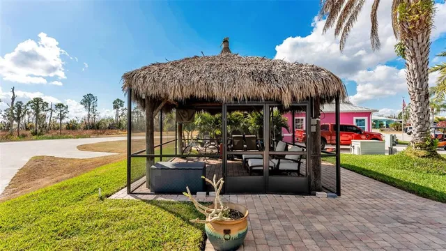 a view of a patio with table and chairs potted plants and a palm tree