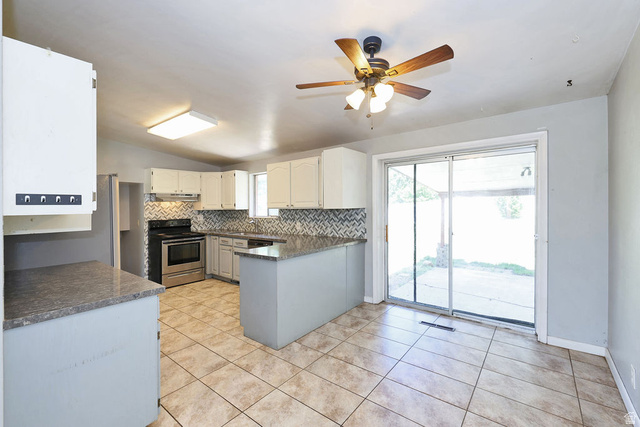 1272 Cook Street Ogden, UT 84404 - Photo 13 of 46 Kitchen featuring tile flooring, white cabinetry, a patterned tile backsplash, and a stainless steel range