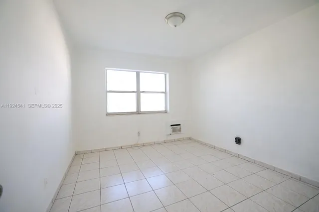 an empty room with white walls and tiles