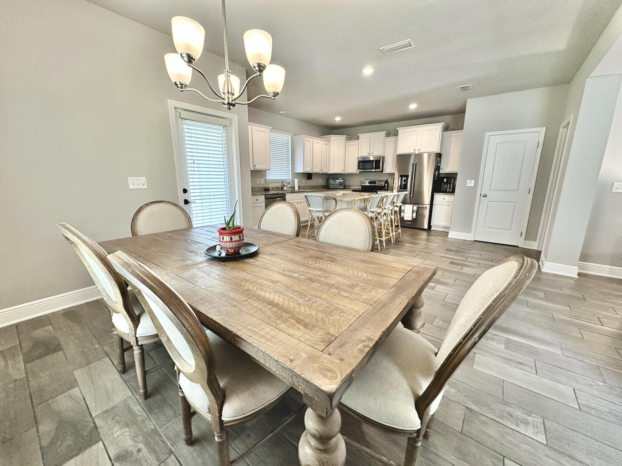 74 Tranquility Lane Santa Rosa Beach, FL 32459 - Photo 11 of 49 a dining room filled chandelier and wooden floor