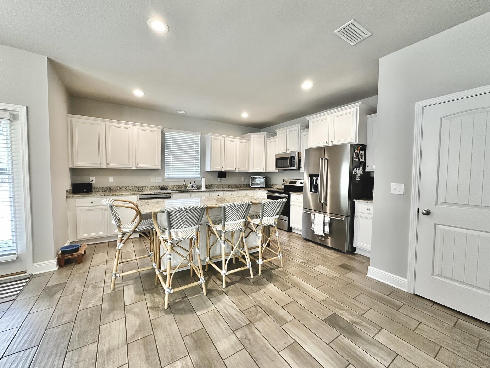 74 Tranquility Lane Santa Rosa Beach, FL 32459 - Photo 12 of 49 a kitchen with stainless steel appliances kitchen island granite countertop a refrigerator and a stove top oven
