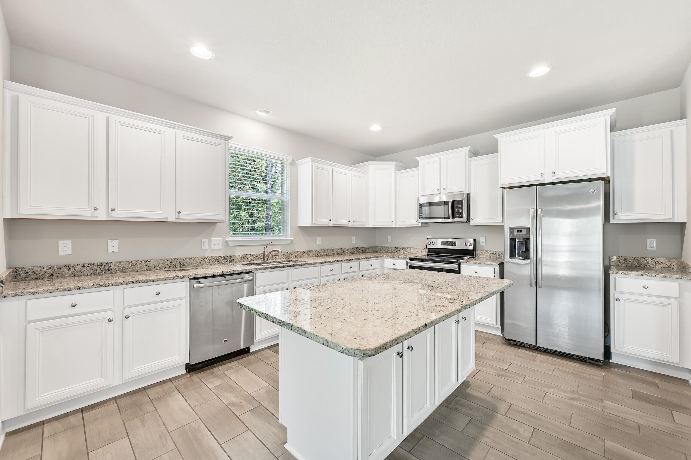 74 Tranquility Lane Santa Rosa Beach, FL 32459 - Photo 15 of 49 a kitchen with a sink stove a refrigerator and white cabinets