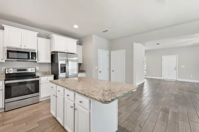 a kitchen with granite countertop a sink stove and refrigerator