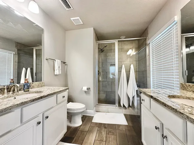a spacious bathroom with a granite countertop sink toilet and shower