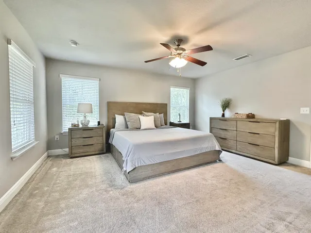 a spacious bedroom with a large bed and a chandelier