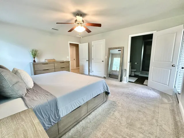 a bedroom with a large bed and a chandelier