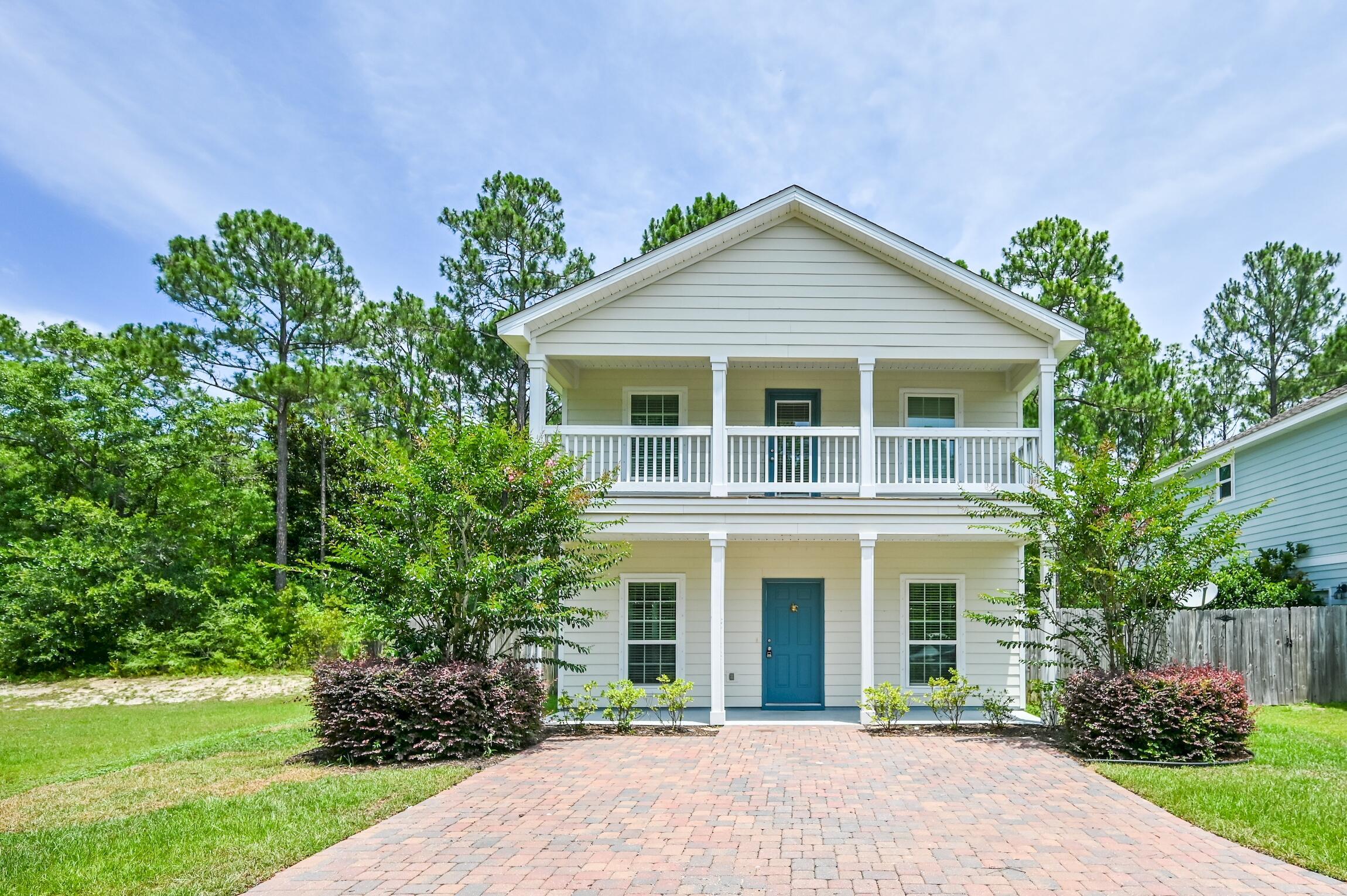 74 Tranquility Lane Santa Rosa Beach, FL 32459 - Photo 3 of 49 a front view of a house with a yard and potted plants