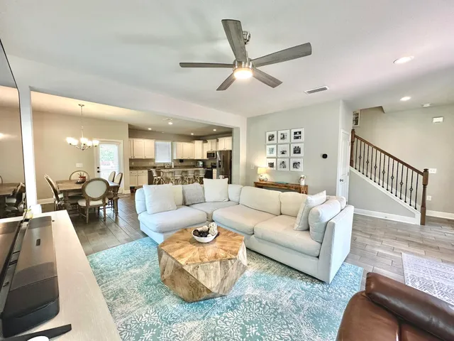 a living room with furniture and a view of kitchen