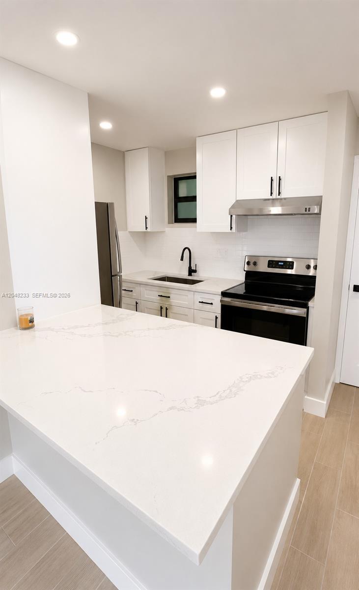 1530 Southwest 2nd Street, Unit 307 Miami, FL 33135 - Photo 4 of 7 a kitchen with stainless steel appliances a stove a sink a refrigerator and cabinets