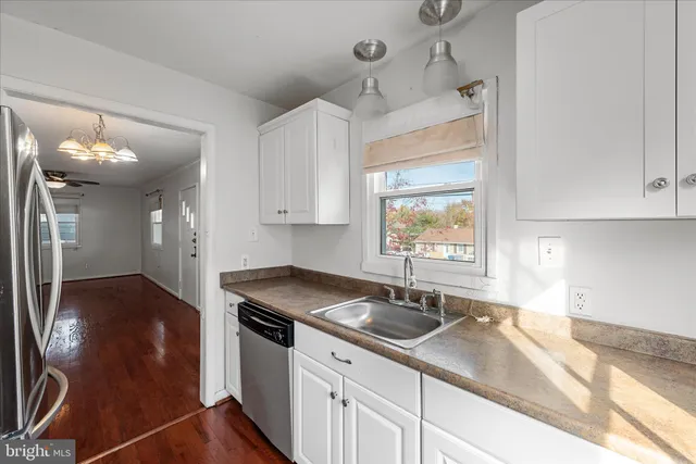 a kitchen with stainless steel appliances granite countertop a sink a stove and a wooden floors