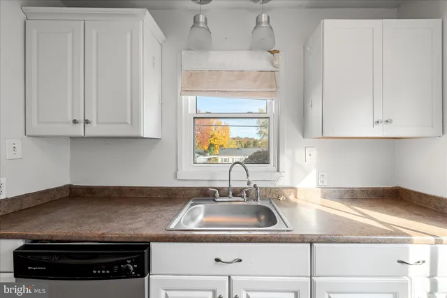 a kitchen with granite countertop a sink a stove and cabinets