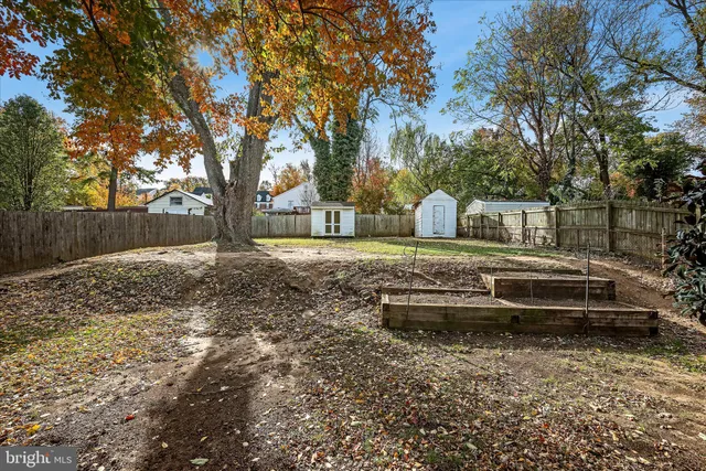 a view of a small house with wooden fence