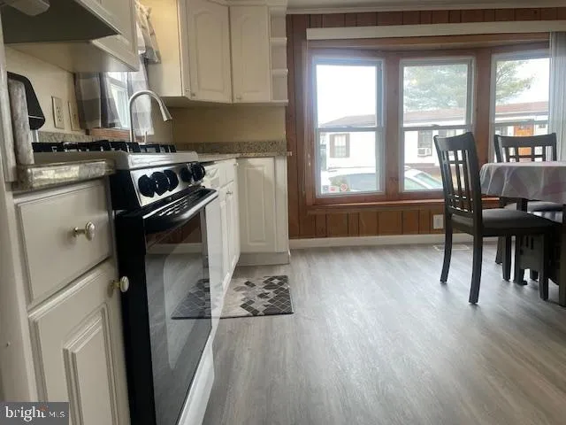 a kitchen with a wooden floor and a refrigerator