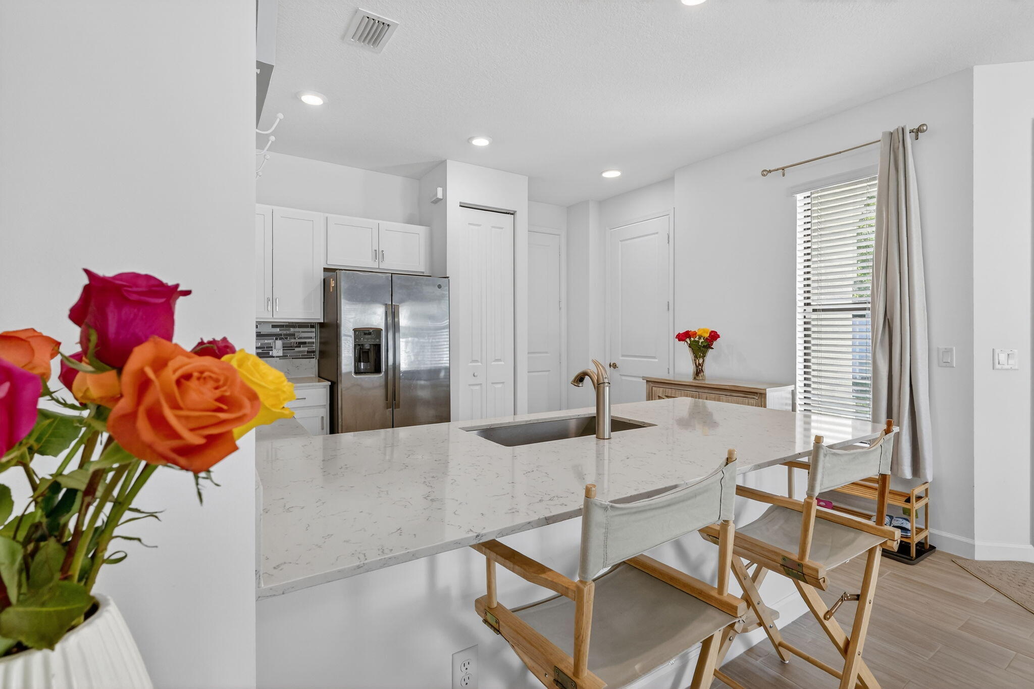 1011 Willow Place Riviera Beach, FL 33410 - Photo 14 of 65 a kitchen with stainless steel appliances kitchen island granite countertop a table chairs in it and wooden floors