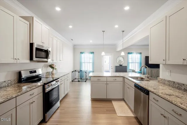 a kitchen with stainless steel appliances granite countertop a sink refrigerator and cabinets