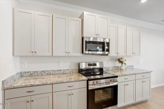 a kitchen with white cabinets and sink