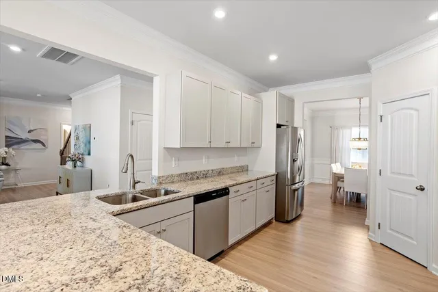 a kitchen with granite countertop white cabinets and white appliances
