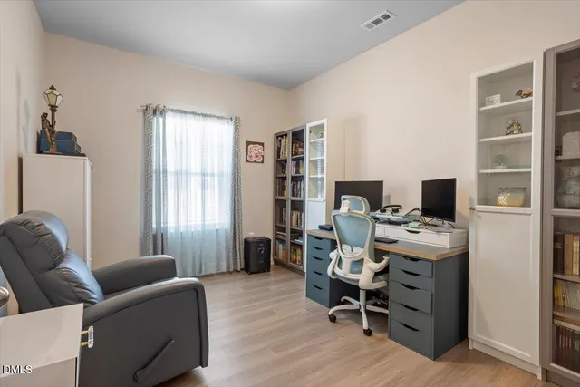 a large kitchen with stainless steel appliances kitchen island granite countertop a refrigerator oven a sink dishwasher and white cabinets with wooden floor