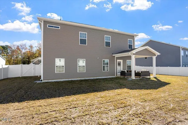 a front view of a house with swimming pool and yard
