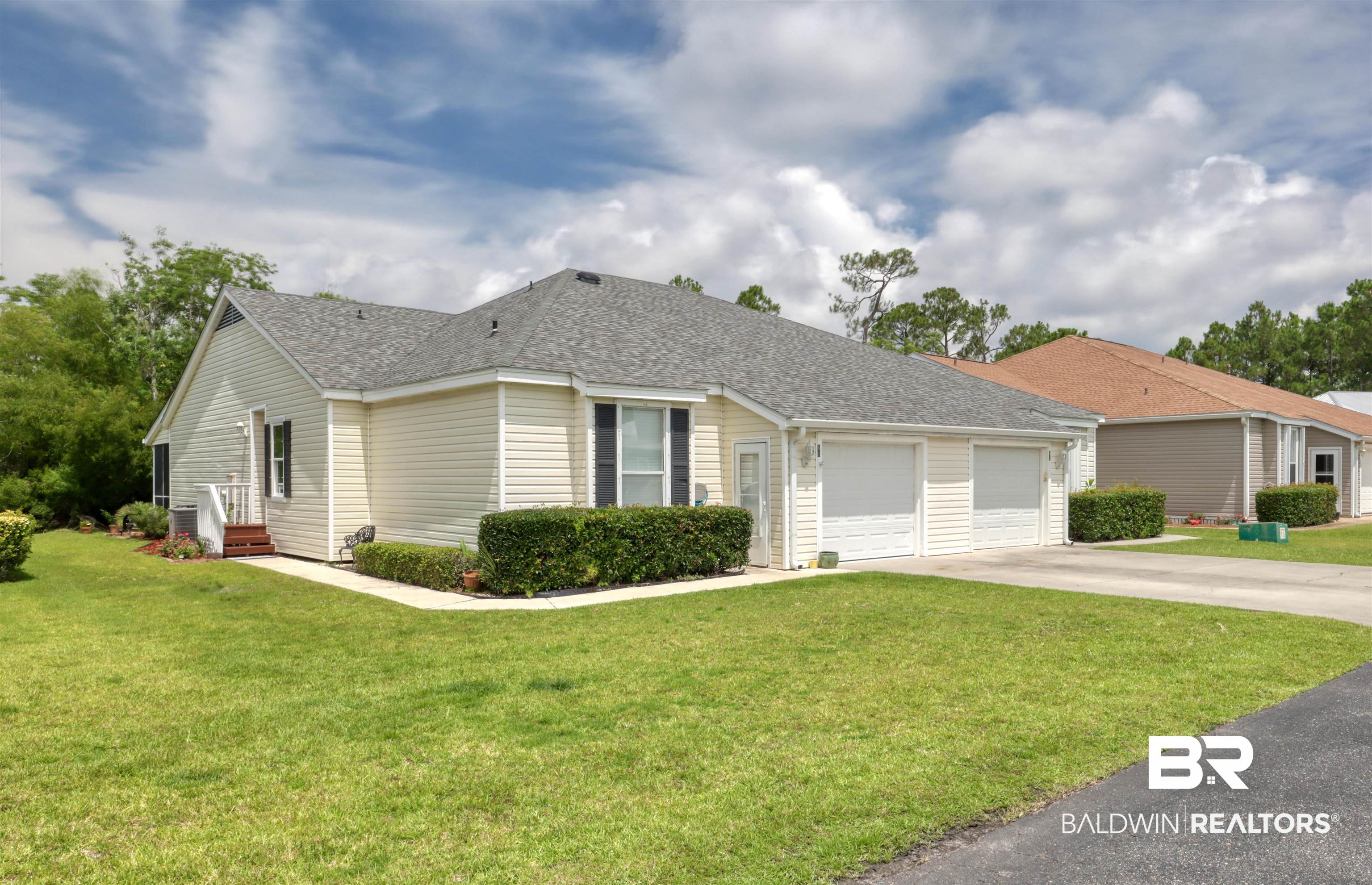 3200 Loop Road, Unit 61 Orange Beach, AL 36561 - Photo 1 of 32 View of front of home with an attached garage, driveway, a front lawn, and roof with shingles