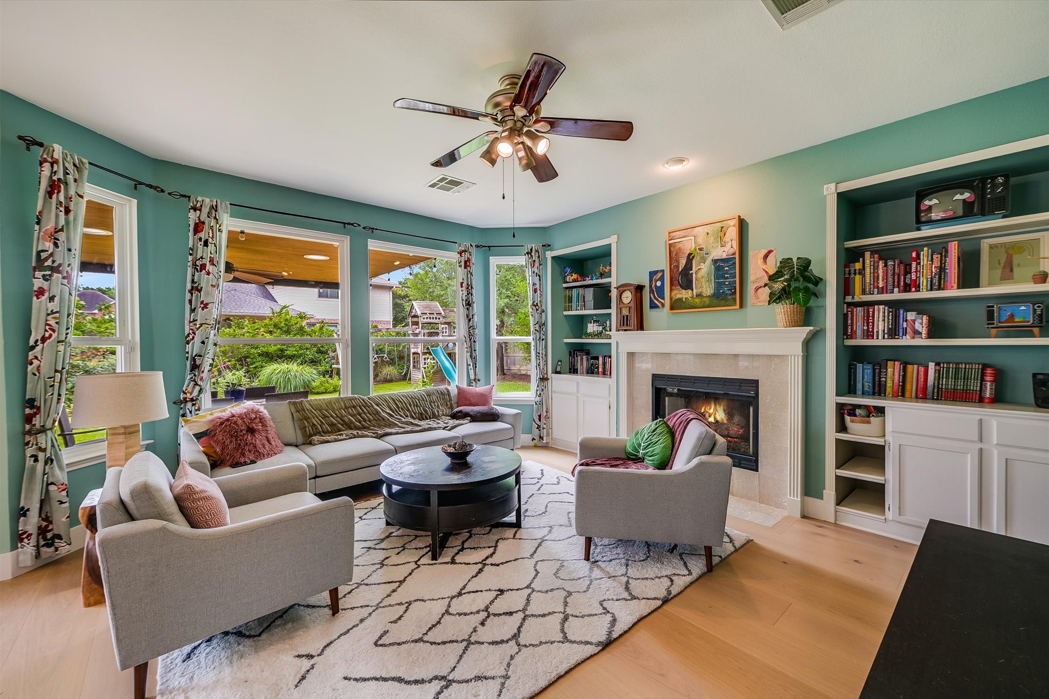 6456 Ruxton Lane Austin, TX 78749 - Photo 8 of 30 A vibrant family room featuring built-in shelving, a fireplace, and bright windows overlooking the private yard.
