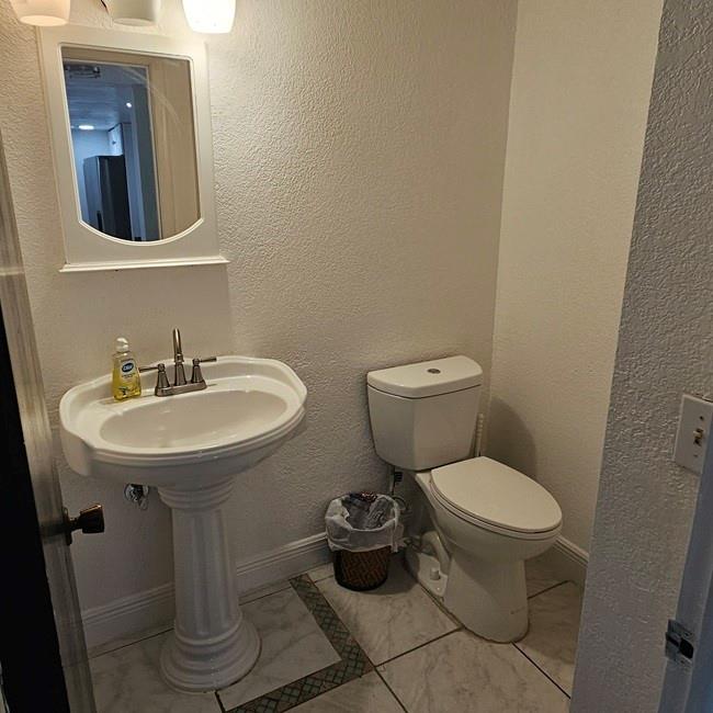 3270 North Pine Island Road, Unit 307 Sunrise, FL 33351 - Photo 12 of 17 a bathroom with a toilet sink and mirror