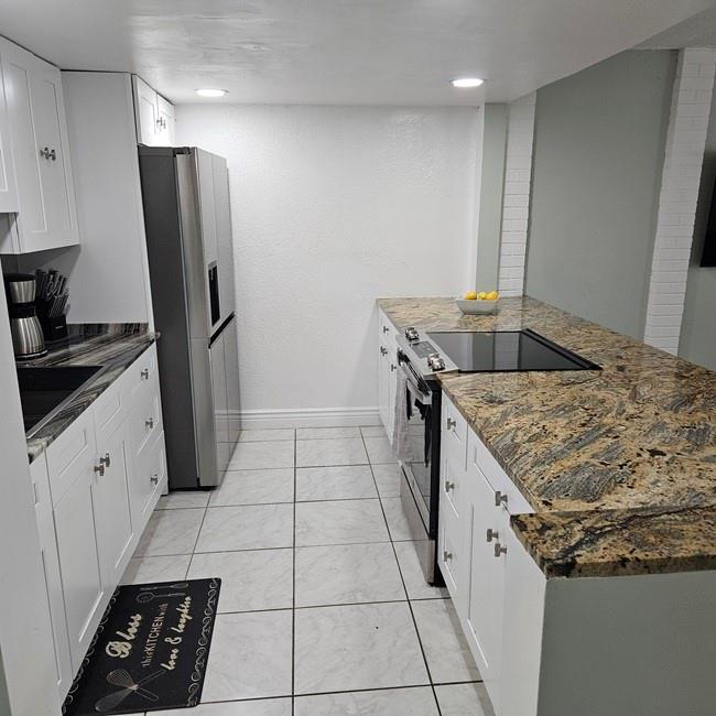 3270 North Pine Island Road, Unit 307 Sunrise, FL 33351 - Photo 3 of 17 a kitchen with granite countertop a sink stove and refrigerator