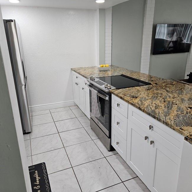 3270 North Pine Island Road, Unit 307 Sunrise, FL 33351 - Photo 5 of 17 a kitchen with granite countertop white cabinets and white appliances
