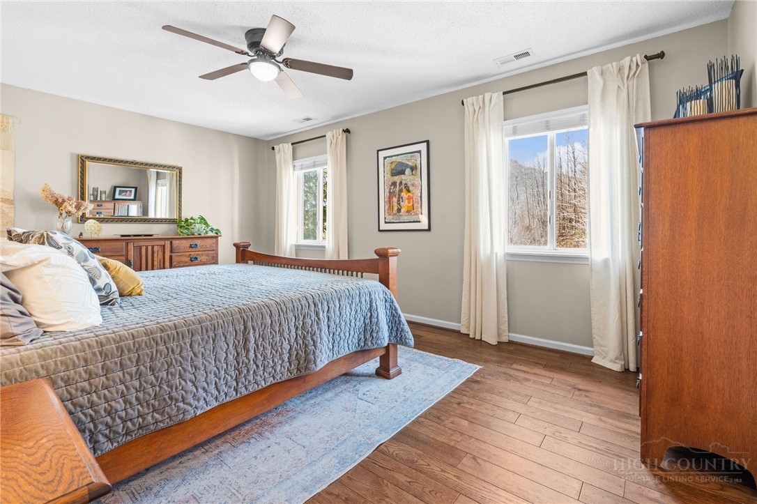 220 Woodwinds Lane Seven Devils, NC 28604 - Photo 16 of 46 a bedroom with a large bed a chandelier and a window